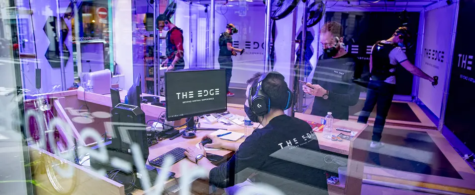 Vue intérieure du centre de réalité virtuelle The Edge avec des utilisateurs équipés et actifs.