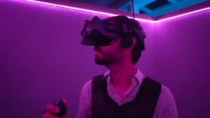 Joueur de profil muni d'une manette et d'un casque de réalité virtuelle