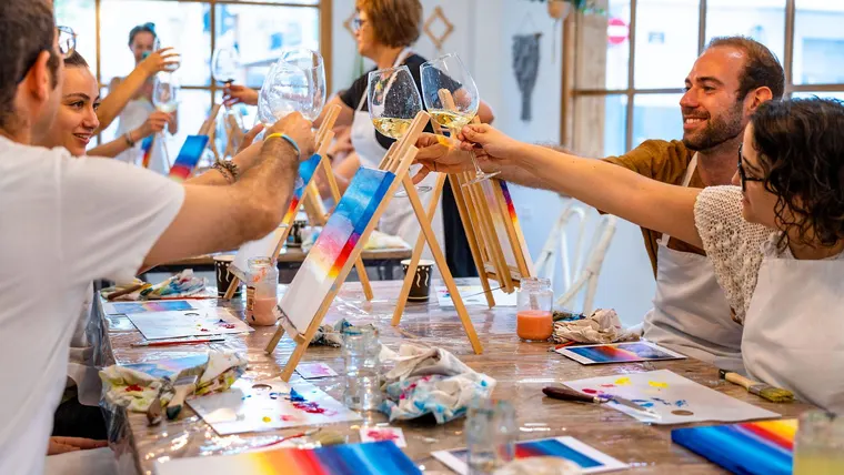 Amis peignant sur toile autour d'un verre lors d'un apéro peinture à Paris