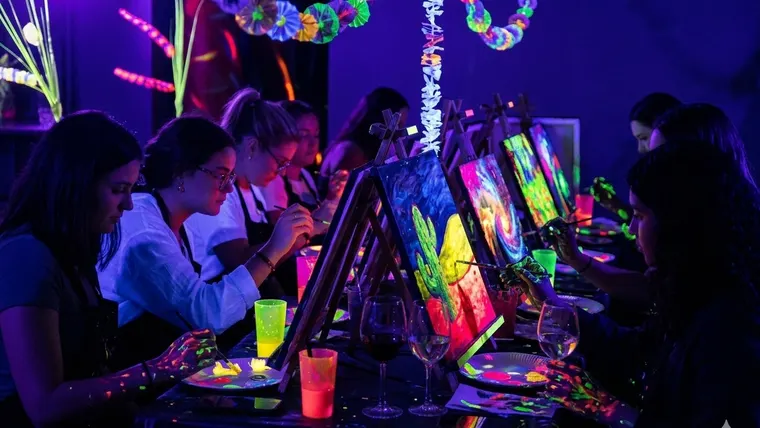 Atelier de peinture fluo sous lumière UV dans le noir à Paris