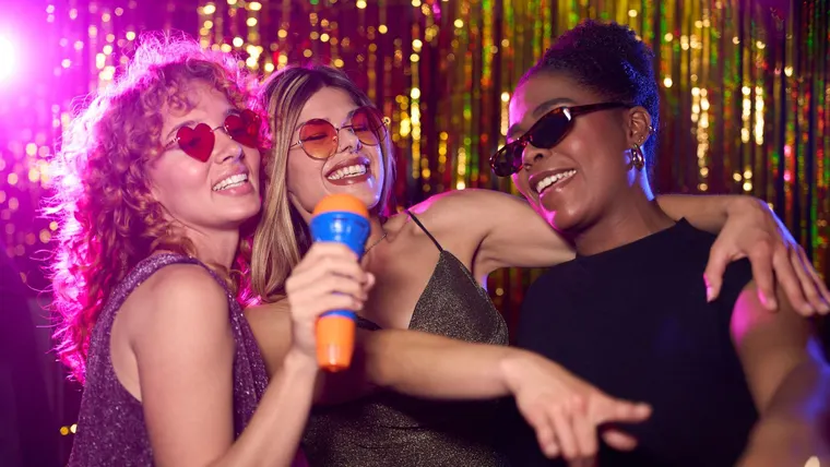 Groupe d'amis chantant au micro lors d'une soirée karaoké à Paris